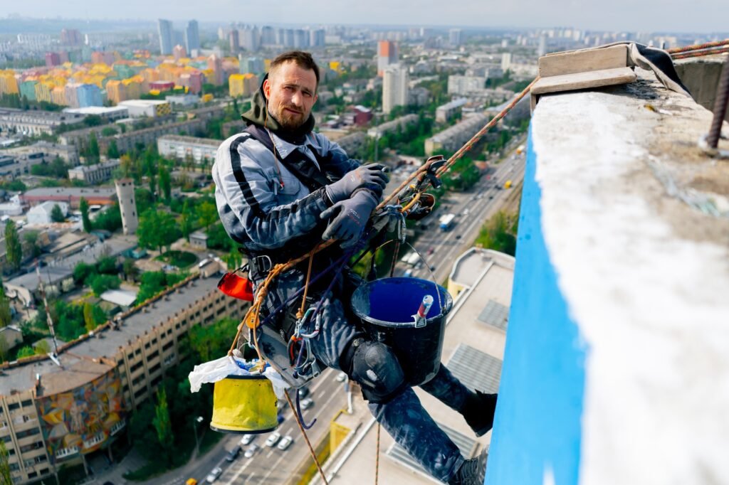 on the roof of a high-rise building against the background of multi-colored bright houses painter
